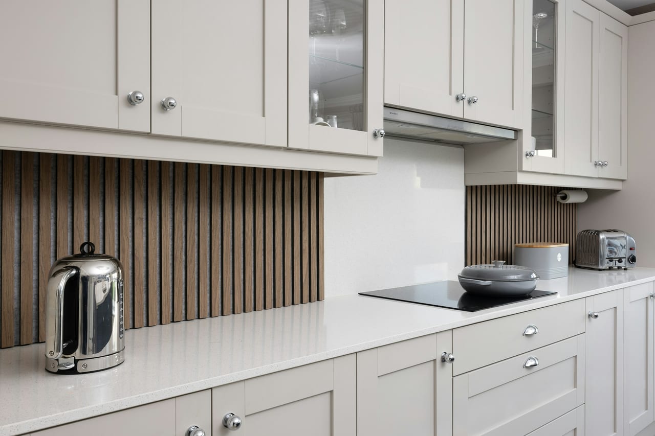 Joinery reference — a working surface meets a ribbed timber backdrop. Independent licensed reference.